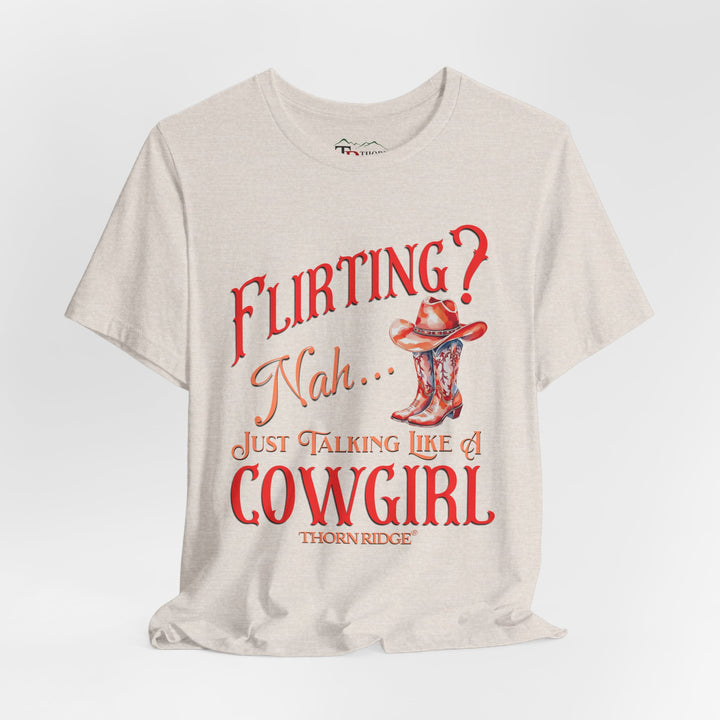 "Flirting? Nah... just talking like a cowgirl" graphic tee with women's cowgirl boots with a cowgirl hat sitting on top. Labeled Thorn Ridge®
