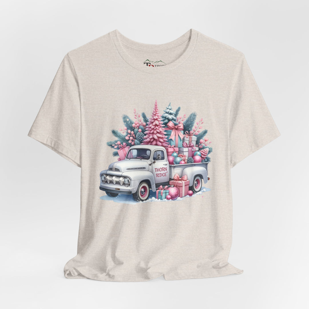 t-shirt with a vintage white truck with the bed filled with pastel colored christmas trees and presents with Thorn ridge on the driver's side door and presents around the door on the ground. 