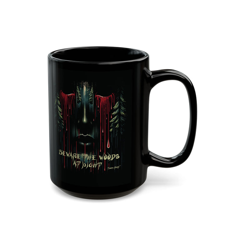 Black mug with a face emerging from the forest with bleeding eyes and a warning Beware the Woods at Night by Thorn Ridge®