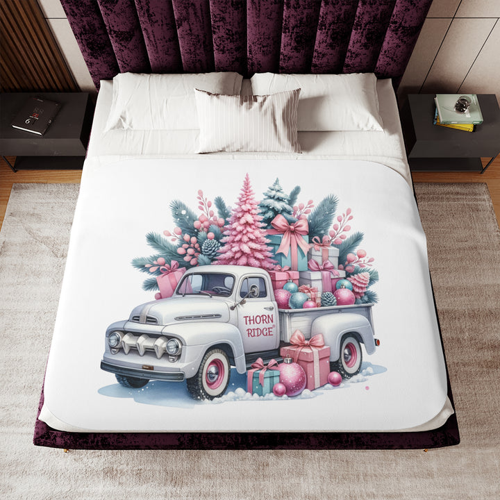 Vintage truck decorated with Christmas trees and presents on a white background with Thorn Ridge® branding on the door. Lying across a bed 