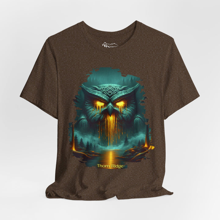 Legend of the Owl King tee by Thorn Ridge with a ancient statue of an owl with glowing lava eyes and mouth in front of a river with fog in the forest. 