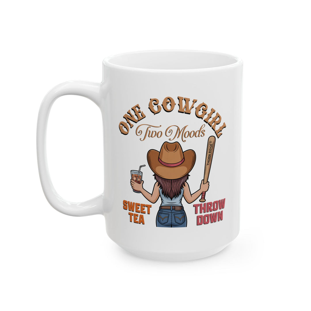 White mug by Thorn Ridge® with a graphic of a cowgirl holding a drink and a bat, with text 'One Cow Girl Two Moods Sweet Tea Throw Down' on a white background.