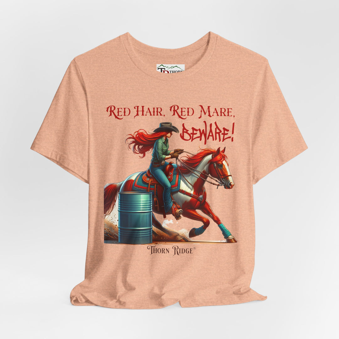 t-shirt with a graphic of a redhead woman on a horse barrel racing and the text 'Red Hair, Red Mare, Beware!' labeled Thorn Ridge®.