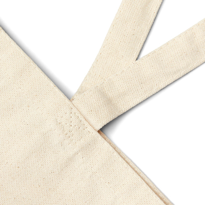 Close-up of beige fabric with a cross pattern on a white background