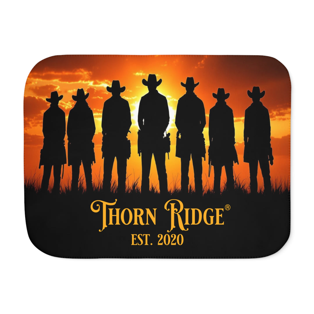 Silhouette of Seven Riders cowboys against an orange sunset with 'Thorn Ridge' branding on a sherpa blanket