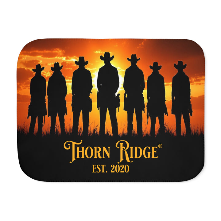 Silhouette of Seven Riders cowboys against an orange sunset with 'Thorn Ridge' branding on a sherpa blanket