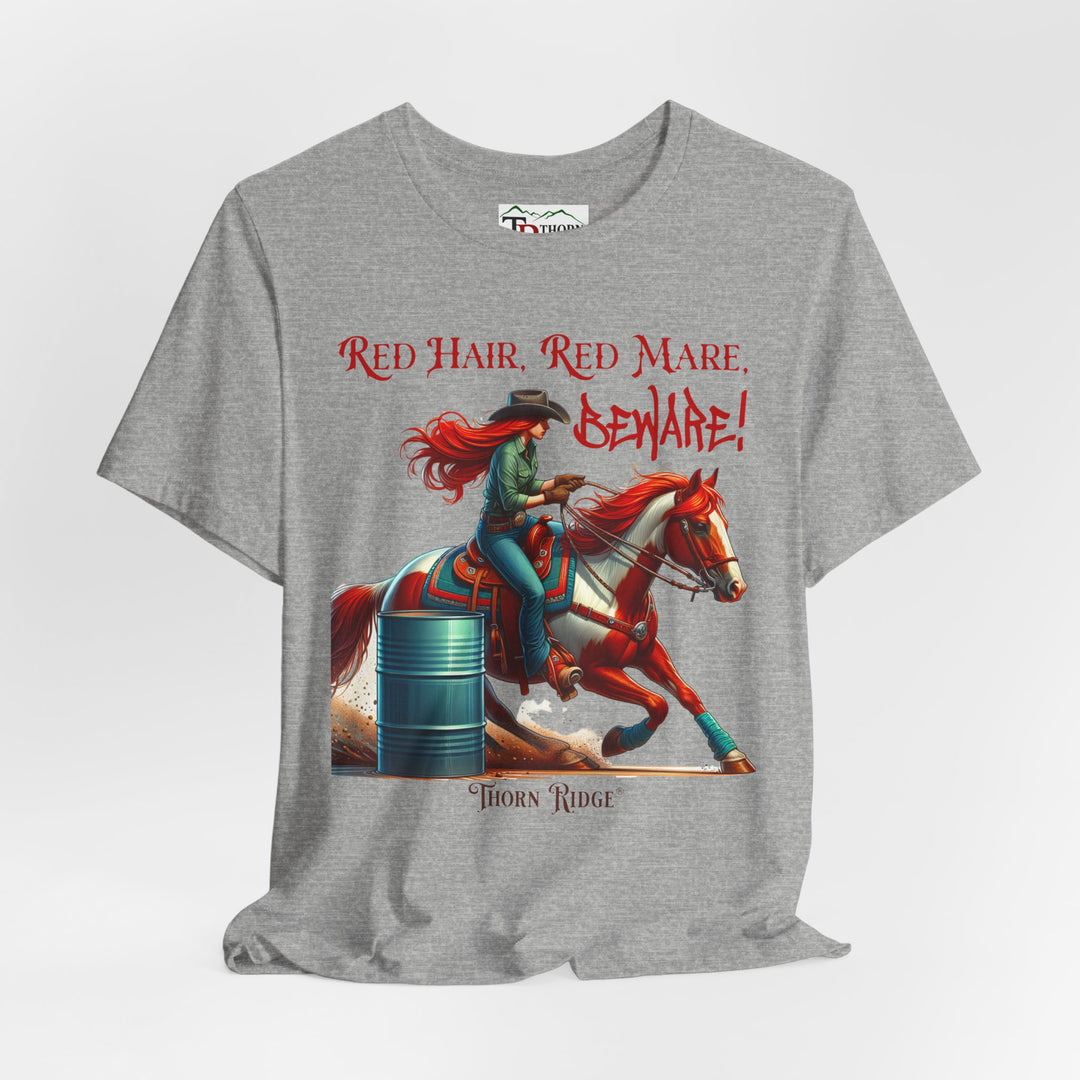t-shirt with a graphic of a redhead woman on a horse barrel racing and the text 'Red Hair, Red Mare, Beware!' labeled Thorn Ridge®.