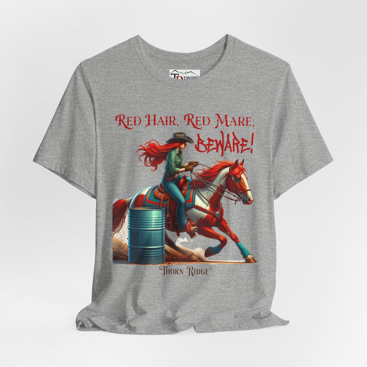 t-shirt with a graphic of a redhead woman on a horse barrel racing and the text 'Red Hair, Red Mare, Beware!' labeled Thorn Ridge®.
