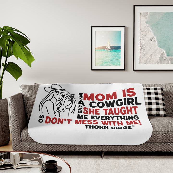 Mom Is A Cowgirl and she taught me everything so don't mess with me slogan graphic with a outline drawing of a woman with a cowboy hat hugging a horse by Thorn Ridge®