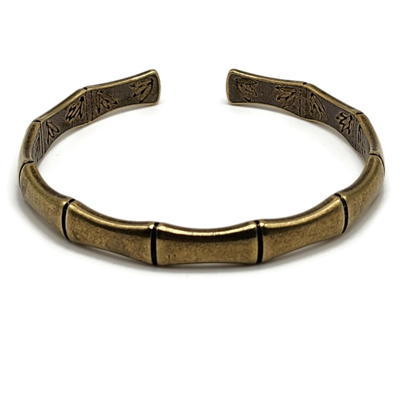 brass and copper Tibetan cuff bracelet is in the shape of bamboo and has images of flowers on the inside
