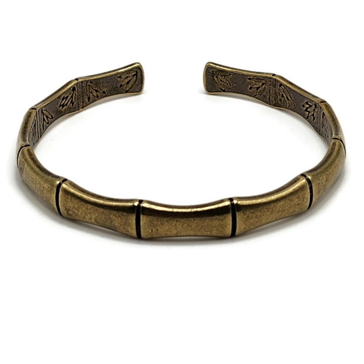 brass and copper Tibetan cuff bracelet is in the shape of bamboo and has images of flowers on the inside