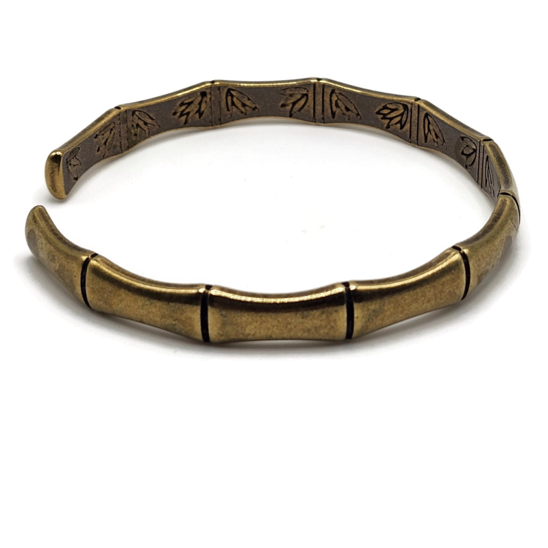 brass and copper Tibetan cuff bracelet is in the shape of bamboo and has images of flowers on the inside