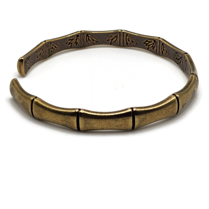 brass and copper Tibetan cuff bracelet is in the shape of bamboo and has images of flowers on the inside