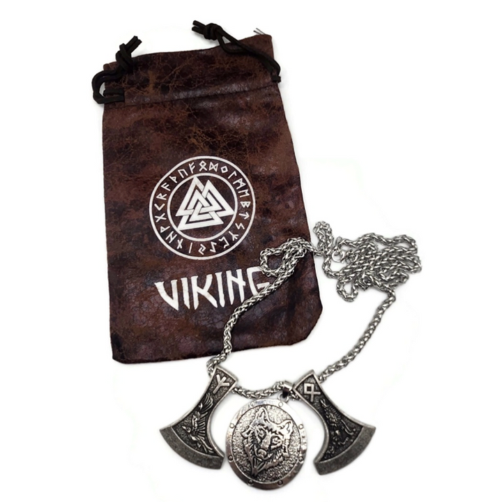 Viking necklace with two axes and a wolf head pendant on a snake chain. Image shows drawsting bag with viking and rune symbols on it. 