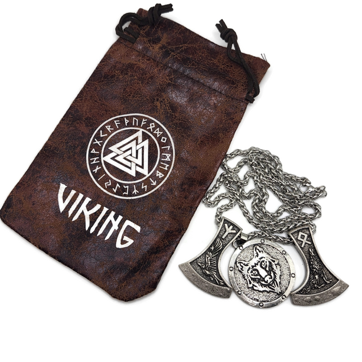 Viking necklace with two axes and a wolf head pendant on a snake chain. Image shows drawsting bag with viking and rune symbols on it. 