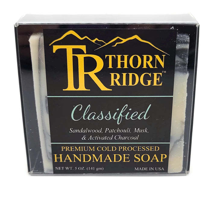 Packaging of Thorn Ridge soap labeled "Classified," described as sandalwood, patchouli, musk, activated charcoal, premium cold processed, handmade, 5 oz. Made in USA.