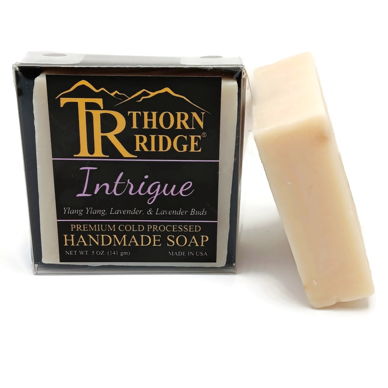 Packaging of Thorn Ridge soap labeled "Intrigue," described as ylang ylang, lavender, lavender buds, premium cold processed, handmade, 5 oz. Made in USA.