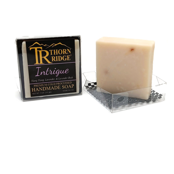 Packaging of Thorn Ridge soap labeled "Intrigue," described as ylang ylang, lavender, lavender buds, premium cold processed, handmade, 5 oz. Made in USA.