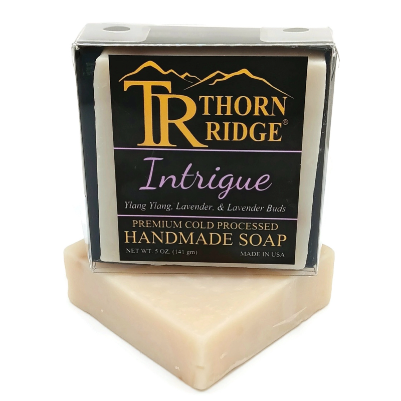 Packaging of Thorn Ridge soap labeled "Intrigue," described as ylang ylang, lavender, lavender buds, premium cold processed, handmade, 5 oz. Made in USA.