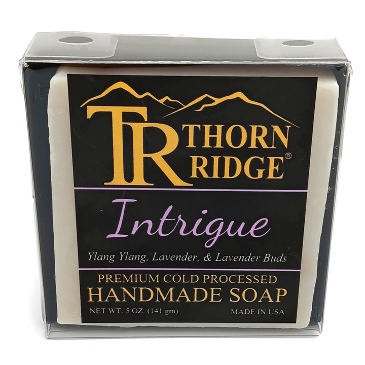 Packaging of Thorn Ridge soap labeled "Intrigue," described as ylang ylang, lavender, lavender buds, premium cold processed, handmade, 5 oz. Made in USA.