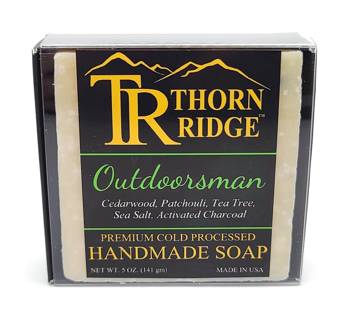 Packaging of Thorn Ridge soap labeled "Outdoorsman," described as cedarwood, patchouli, tea tree, sea salt, activated charcoal, premium cold processed, handmade, 5 oz. Made in USA.