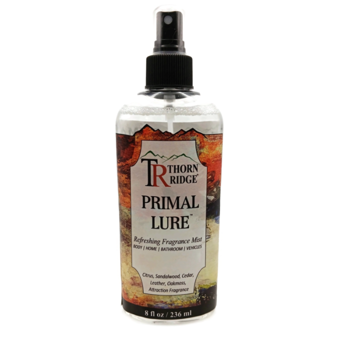 A bottle of Thorn Ridge fragrance mist labeled "Primal Lure," described as a citrus, sandalwood, cedar, leather, oakmoss, attraction scent for body, home, bathroom, and vehicles. 8 fl oz.