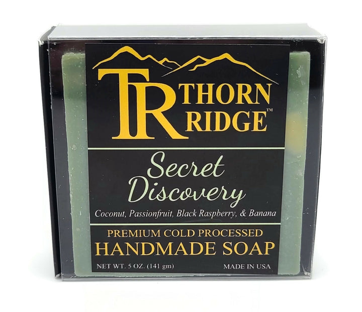 Packaging of Thorn Ridge soap labeled "Secret Discovery," described as coconut, passionfruit, black raspberry, banana, premium cold processed, handmade, 5 oz. Made in USA.