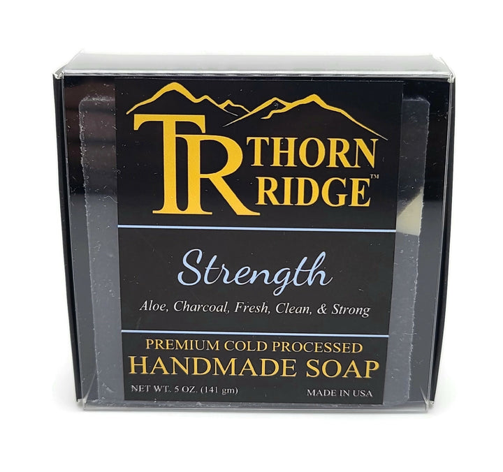 Packaging of Thorn Ridge soap labeled "Strength," described as aloe, charcoal, clean and strong, premium cold processed, handmade, 5 oz. Made in USA.