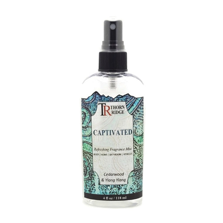 A bottle of Thorn Ridge fragrance mist labeled "Captivated," described as a cedarwood and ylang ylang scent for body, home, bathroom, and vehicles. 4 fl oz.