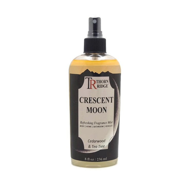 A bottle of Thorn Ridge fragrance mist labeled "Crescent Moon," described as a cedarwood and tea tree scent for body, home, bathroom, and vehicles. 8 fl oz.