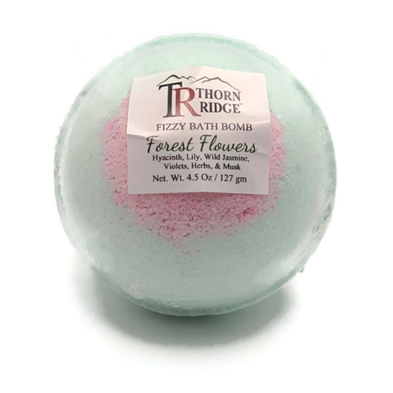 A Thorn Ridge fizzy bath bomb labeled "Forest Flowers," described as a hyacinth, lily, wild jasmine, violets, herbs, and musk fragrance. 4.5 oz.