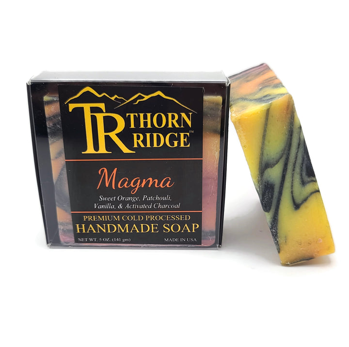 Packaging of Thorn Ridge soap labeled "Magma," described as sweet orange, patchouli, vanilla, activated charcoal, premium cold processed, handmade, 5 oz. Made in USA.