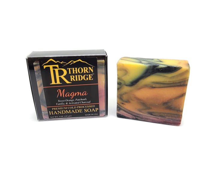 Packaging of Thorn Ridge soap labeled "Magma," described as sweet orange, patchouli, vanilla, activated charcoal, premium cold processed, handmade, 5 oz. Made in USA.