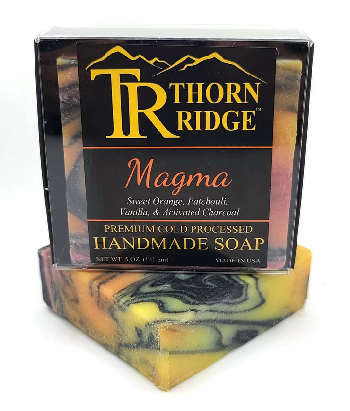 Packaging of Thorn Ridge soap labeled "Magma," described as sweet orange, patchouli, vanilla, activated charcoal, premium cold processed, handmade, 5 oz. Made in USA.