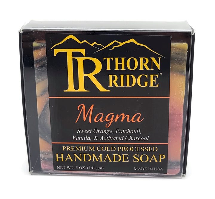 Packaging of Thorn Ridge soap labeled "Magma," described as sweet orange, patchouli, vanilla, activated charcoal, premium cold processed, handmade, 5 oz. Made in USA.