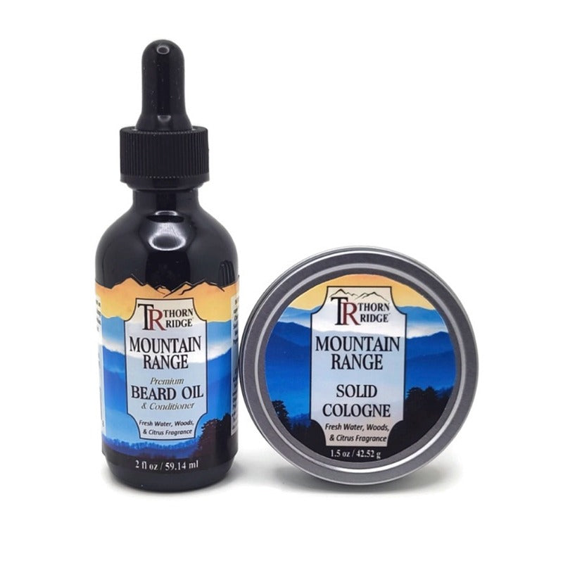 Packaging of Thorn Ridge gift set containing a 2 oz bottle of beard oil and a 1.5 oz tin can of solid cologne described as a fresh water, woods, and citrus fragrance and labeled "Mountain Range," Made in USA.