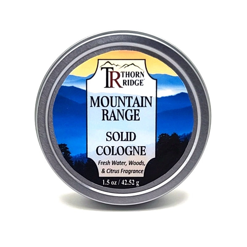 A silver tin of Thorn Ridge solid cologne labeled "Mountain Range," described as a fresh water, woods, and citrus  fragrance. 1.5 oz.