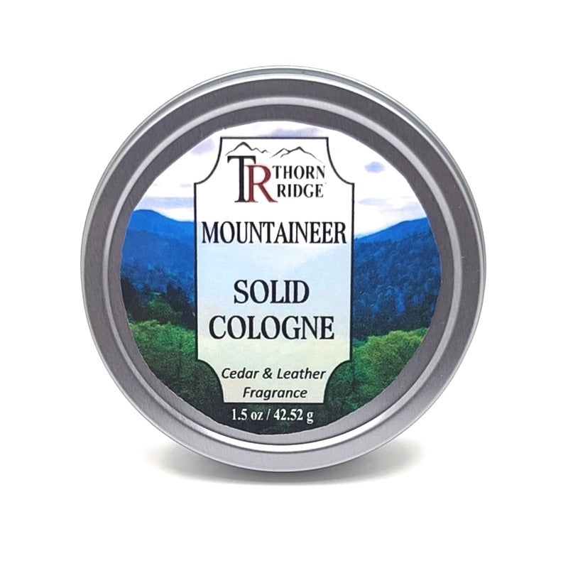 A silver tin of Thorn Ridge solid cologne labeled "Mountaineer," described as a cedar and leather fragrance. 1.5 oz.