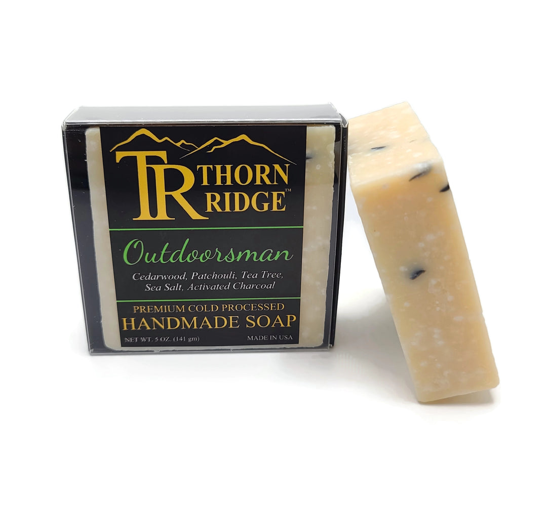 Packaging of Thorn Ridge soap labeled "Outdoorsman," described as cedarwood, patchouli, tea tree, sea salt, activated charcoal, premium cold processed, handmade, 5 oz. Made in USA.