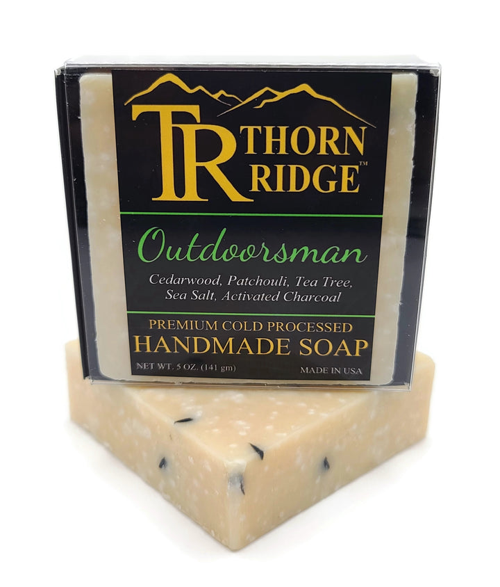 Packaging of Thorn Ridge soap labeled "Outdoorsman," described as cedarwood, patchouli, tea tree, sea salt, activated charcoal, premium cold processed, handmade, 5 oz. Made in USA.