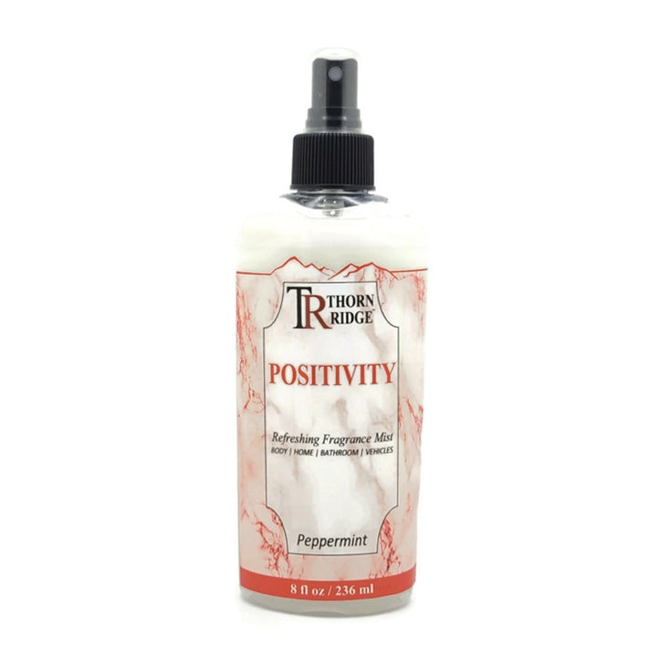 A bottle of Thorn Ridge fragrance mist labeled "Positivity," described as a peppermint scent for body, home, bathroom, and vehicles. 8 fl oz.