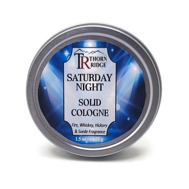 A silver tin of Thorn Ridge solid cologne labeled "Saturday Night," described as a fire, whiskey, hickory, and suede  fragrance. 1.5 oz.