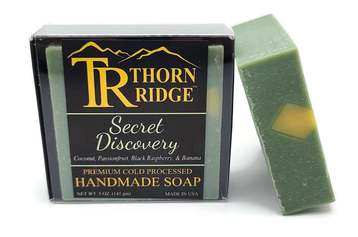 Packaging of Thorn Ridge soap labeled "Secret Discovery," described as coconut, passionfruit, black raspberry, banana, premium cold processed, handmade, 5 oz. Made in USA.