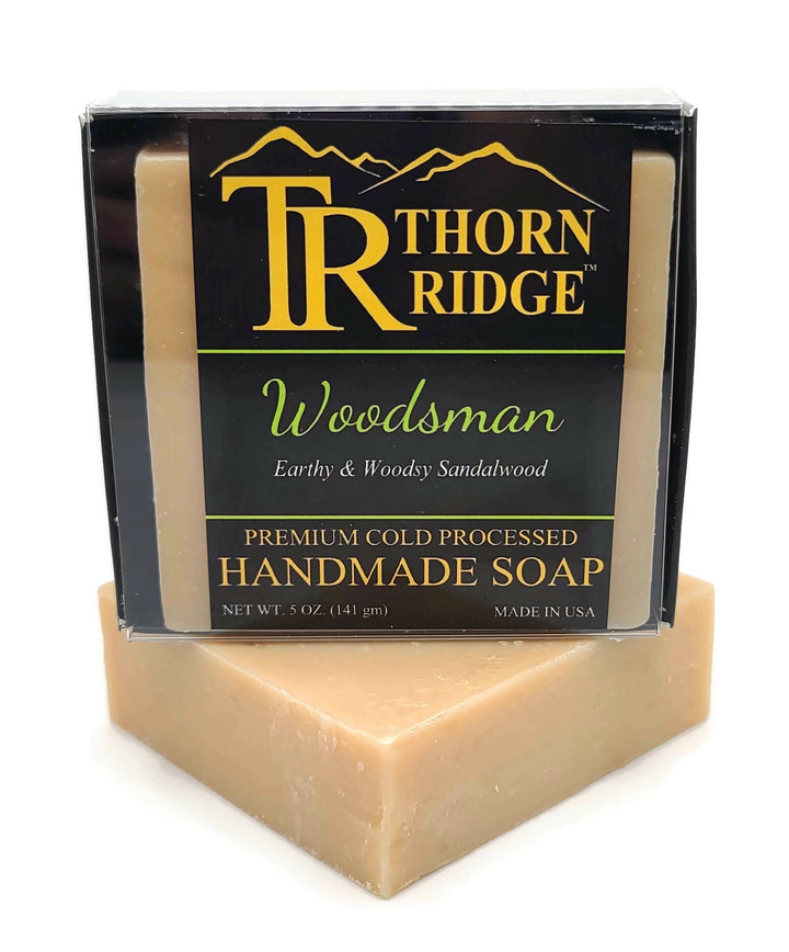 Packaging of Thorn Ridge soap labeled "Woodsman," described as earthy and woodsy sandalwood, premium cold processed, handmade, 5 oz. Made in USA.