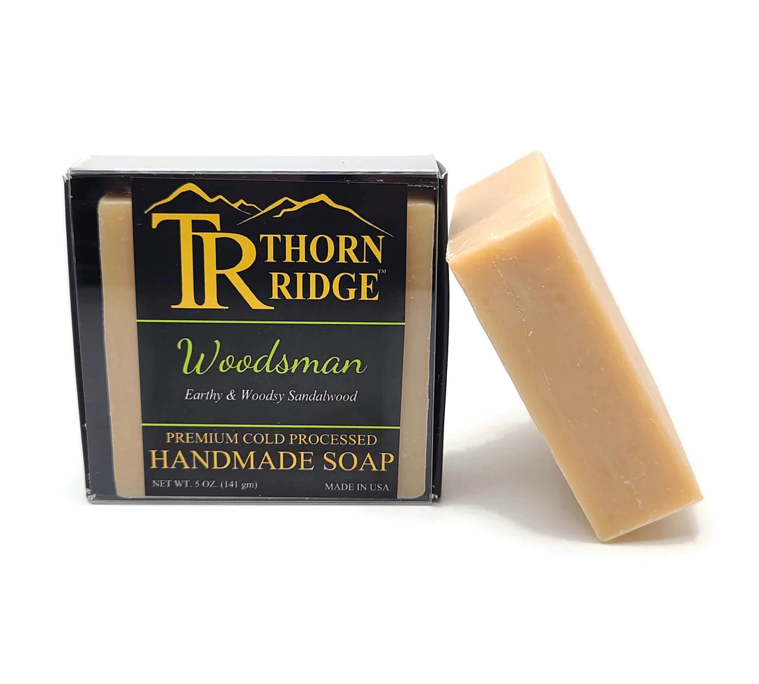 Packaging of Thorn Ridge soap labeled "Woodsman," described as earthy and woodsy sandalwood, premium cold processed, handmade, 5 oz. Made in USA.