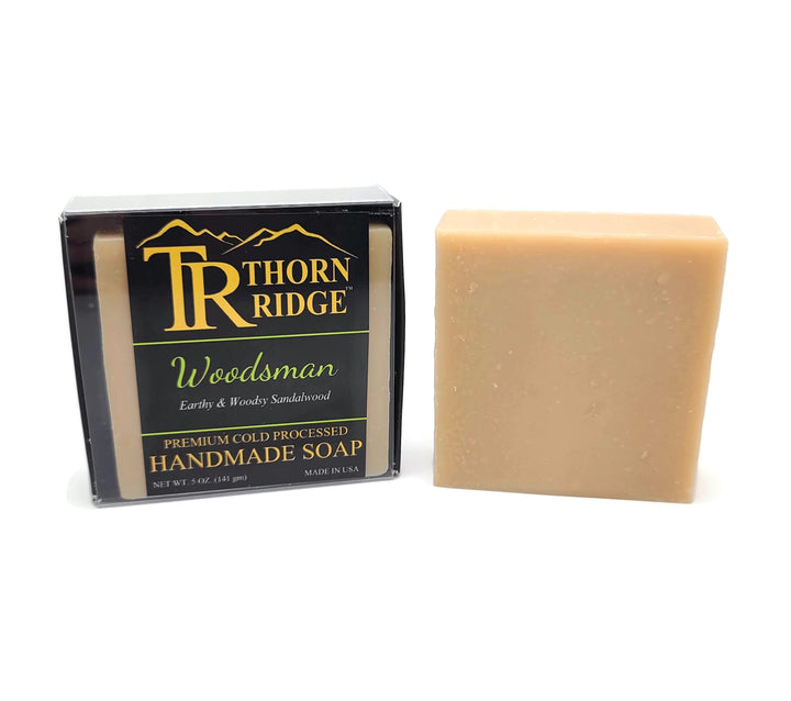 Packaging of Thorn Ridge soap labeled "Woodsman," described as earthy and woodsy sandalwood, premium cold processed, handmade, 5 oz. Made in USA.