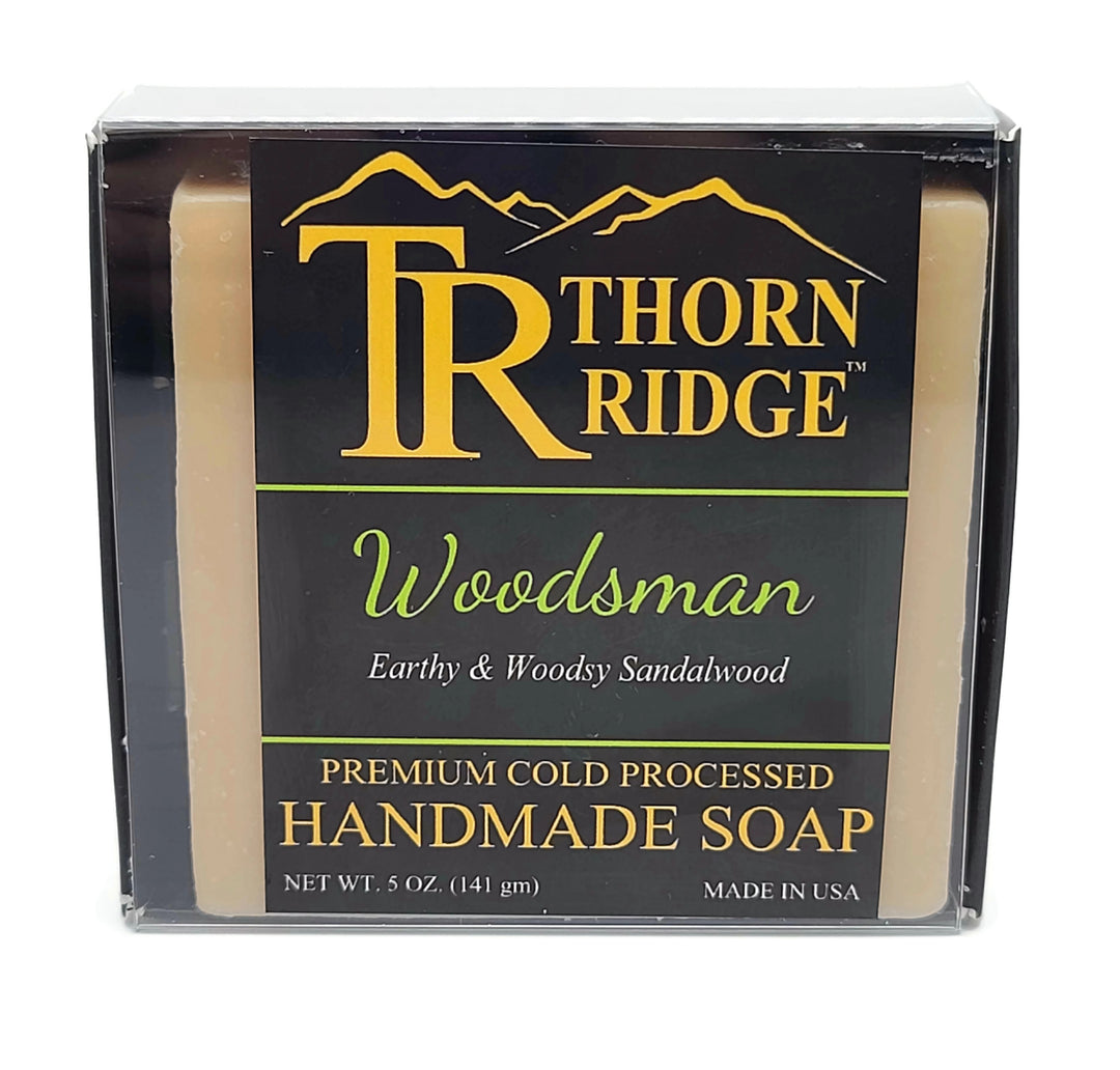 Packaging of Thorn Ridge soap labeled "Woodsman," described as earthy and woodsy sandalwood, premium cold processed, handmade, 5 oz. Made in USA.