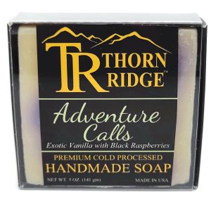 Packaging of Thorn Ridge soap labeled "Adventure Calls," described as exotic vanilla with black raspberries, premium cold processed, handmade, 5 oz. Made in USA.