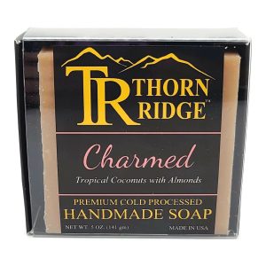 Packaging of Thorn Ridge soap labeled "Charmed," described as tropical coconuts with almonds, premium cold processed, handmade, 5 oz. Made in USA.