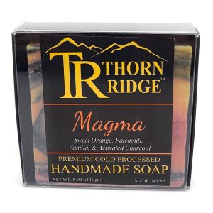 Packaging of Thorn Ridge soap labeled "Magma," described as sweet orange, patchouli, vanilla, activated charcoal, premium cold processed, handmade, 5 oz. Made in USA.